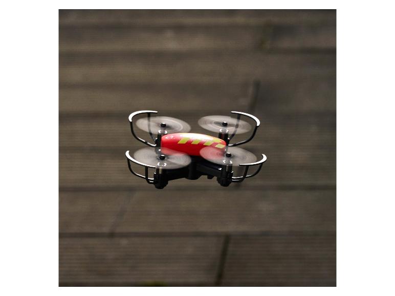 Eine rot-gelbe Drohne mit vier Propellern im Flug.