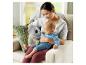 Mutter und Baby sitzen auf einem Sofa mit einem leuchtenden Koala-Plüschtier.