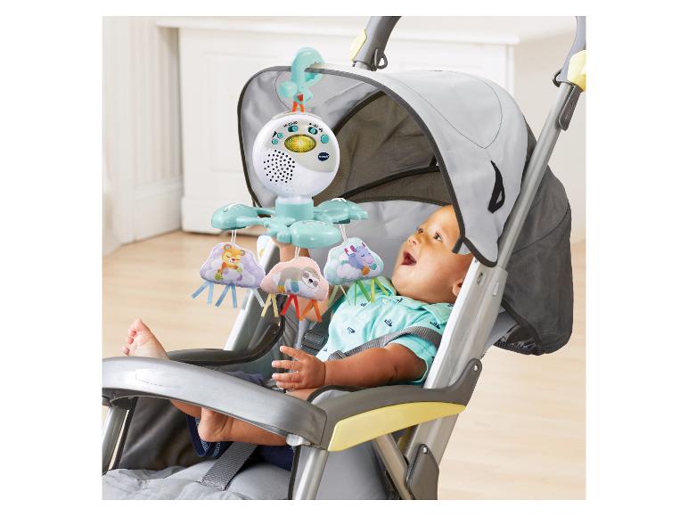 Baby im Kinderwagen schaut auf ein hängendes Mobile mit wolkenförmigen Spielzeugen.