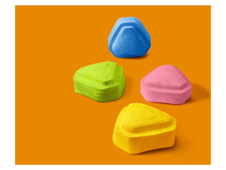 Vier farbige dreieckige Make-up-Schwämme auf orangefarbenem Hintergrund.