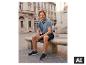 Mann sitzt auf einer Bank in blauem Poloshirt und ESMARA MEN Shorts. [KI-generiertes Bild]