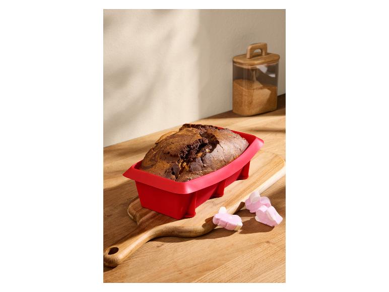 Marmorkuchen in einer roten Silikon-Kastenform auf einem Holzschneidebrett