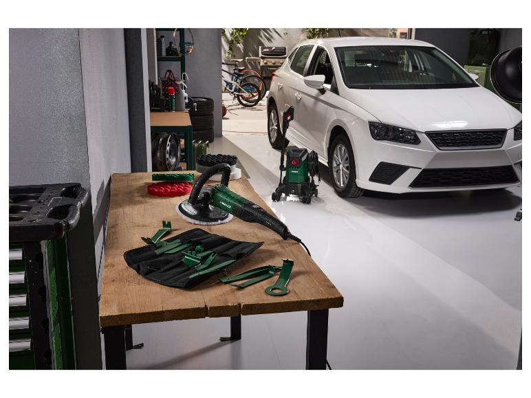 Auto-Poliermaschine und Hochdruckreiniger in einer Garage mit weißem Auto.