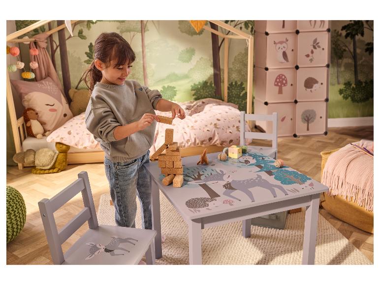 Kind spielt mit Holzklötzen an einem Waldtisch im Kinderzimmer.