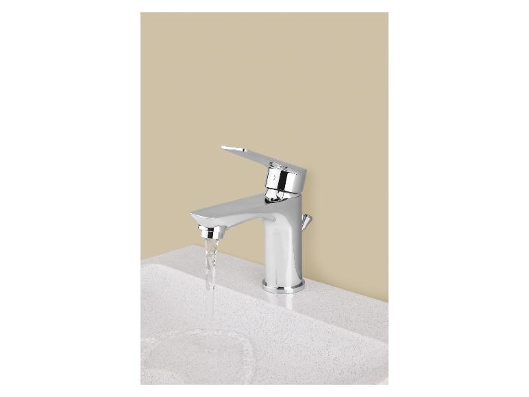 Verchromter Wasserhahn mit fließendem Wasser in einem weißen Waschbecken.