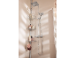 Dusche mit quadratischem Regenduschkopf, Handbrause und Eckablage mit Pflegeprodukten.