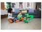 Zwei Jungen spielen mit einem Monstertruck-Streckenset mit einem grünen Drachen.