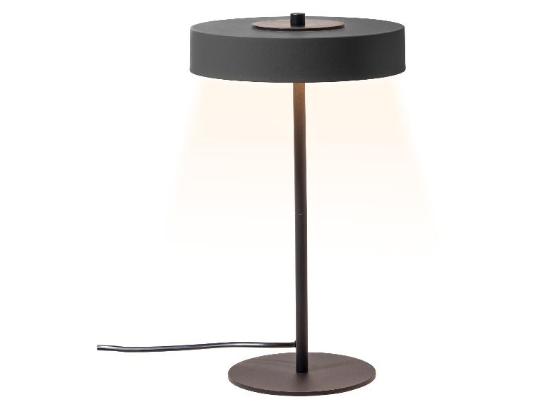 Schwarze Tischlampe mit rundem Fuß und Schirm, der warmes Licht abgibt.