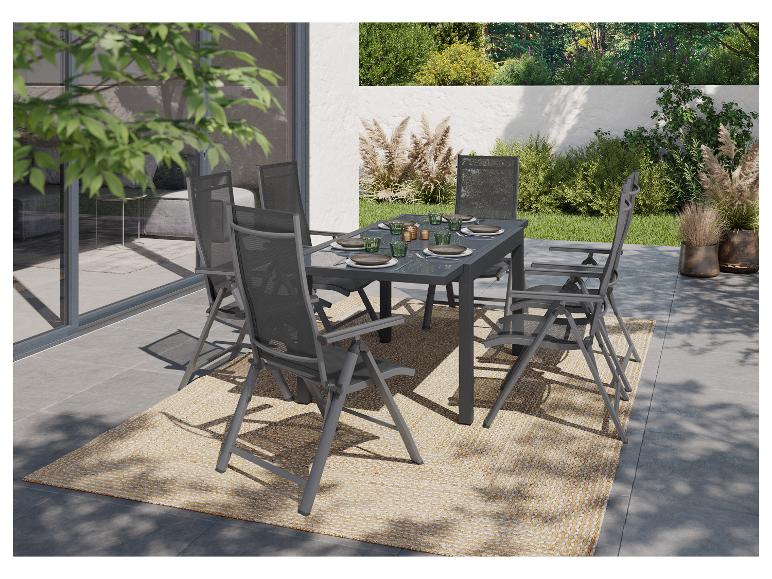 Gartenmöbel-Set mit grauem Tisch und Stühlen auf einer Terrasse mit Teppich.