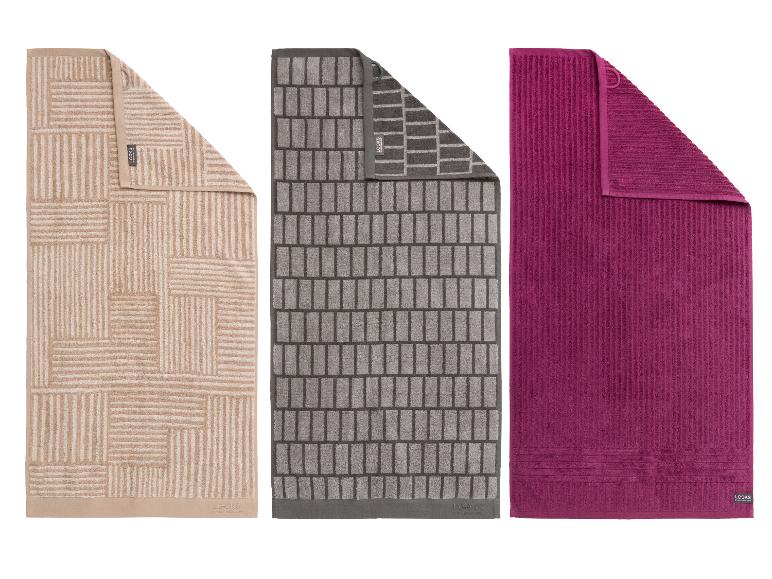 Drei Badetücher: beige mit geometrischem Muster, grau mit Ziegelmuster und einfarbig fuchsia.