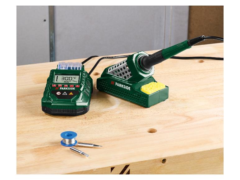 Lötstation mit Digitalanzeige, Lötspitzen und Lötzinn auf einem Holztisch.