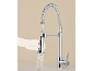 Verchromte Küchenarmatur mit ausziehbarem Brausekopf und Federdesign, eine Hand hält den Wasser sprühenden Kopf.