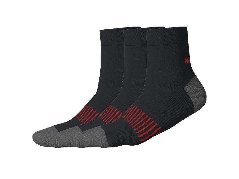 Drei Paar schwarze Socken mit roten Streifen und grauen Zehen und Fersen.