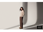 Frau in beigem Pullover, brauner Hose und Wildlederstiefeln im Studio.
