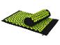 Schwarze Akupressurmatte und Kissen mit grünen Stacheln.