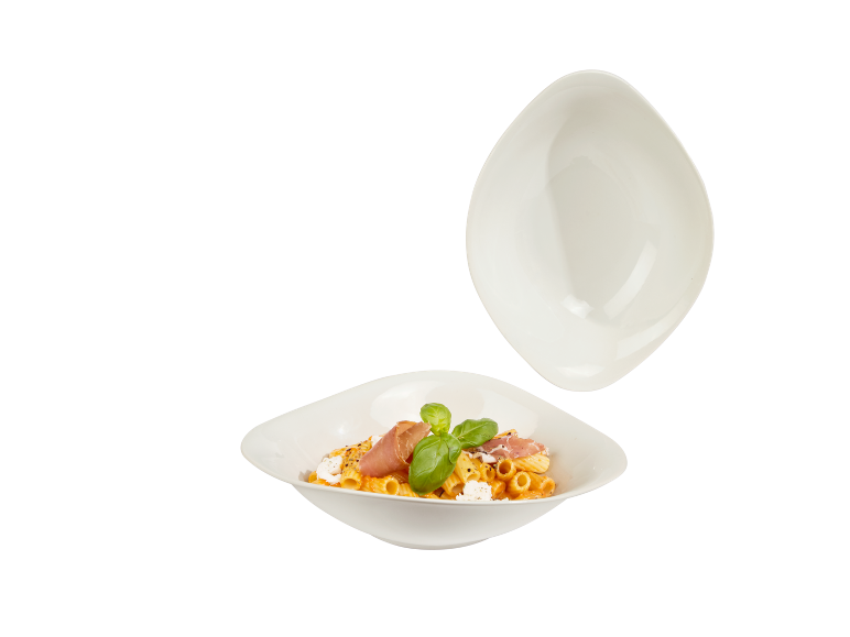 Nudeln mit Tomatensauce, Prosciutto, Basilikum und Käse in zwei weißen quadratischen Schalen.