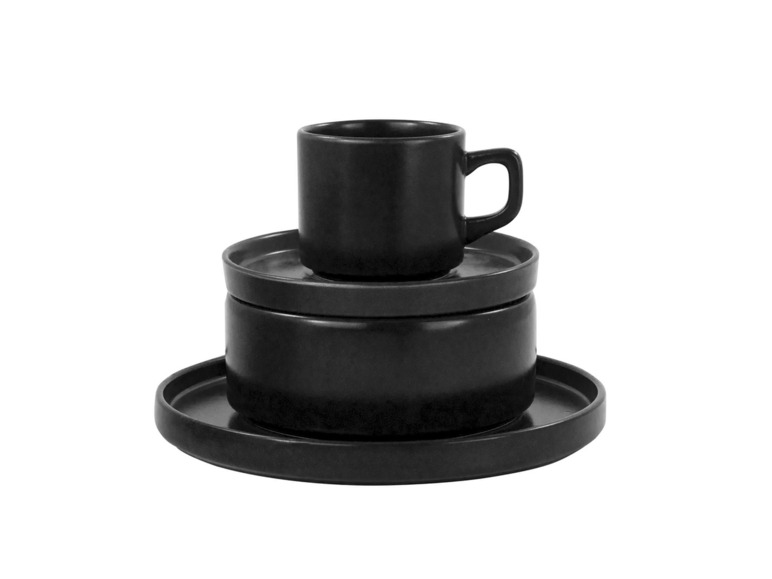 Eine schwarze Tasse mit zwei Untertassen.