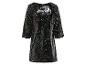 Ein schwarzes, kurzes Kleid mit langen Ärmeln, bedeckt mit Pailletten.