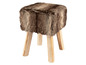 Ein Fellhocker mit Holzbeinen.