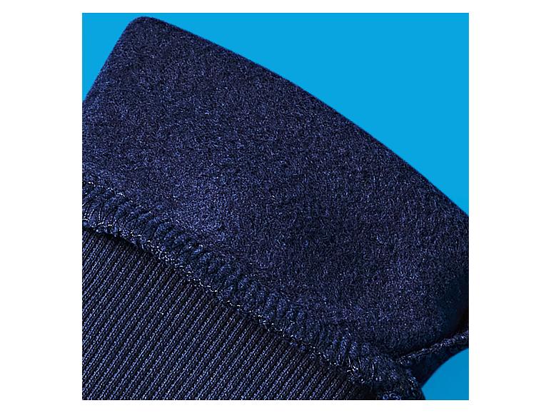 Nahaufnahme von dunkelblauem Stoff mit einer strukturierten, leicht flauschigen Oberfläche und sichtbaren Nähten