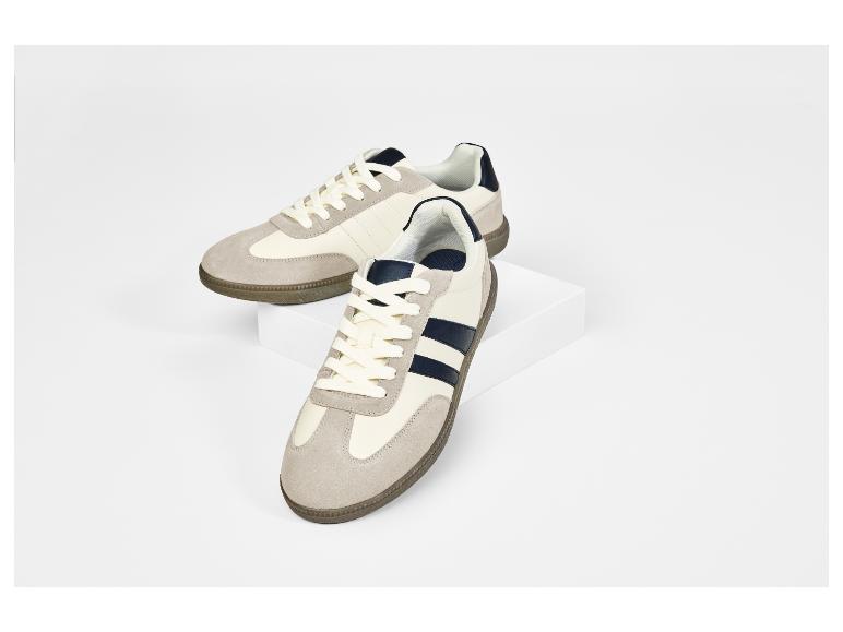 Zwei beige und marineblaue Sneaker auf weißem Hintergrund.