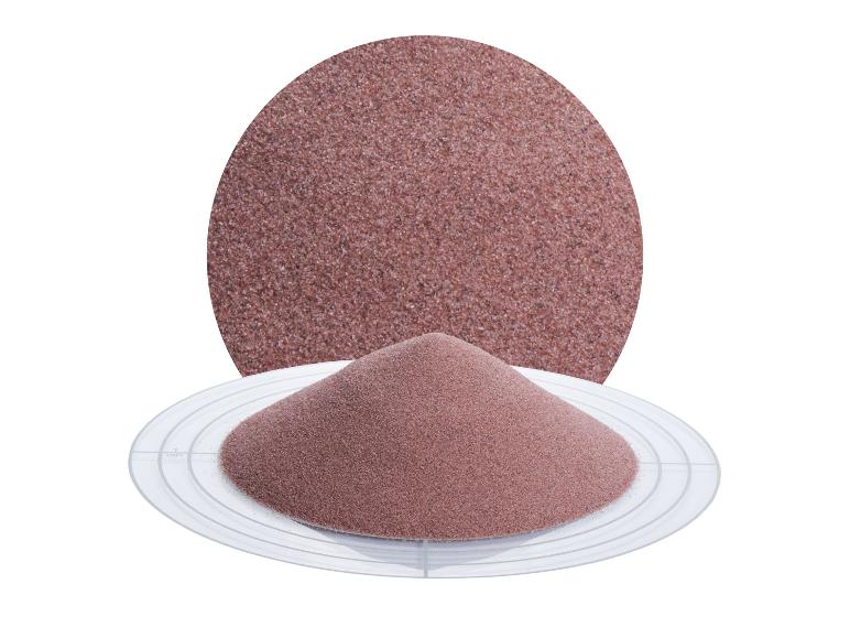 Haufen roter Granatsand auf einer Messplatte, mit einem vergrößerten Kreis im Hintergrund.
