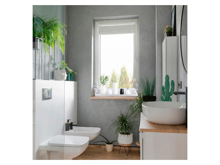 Modernes Badezimmer mit Pflanzen, Toilette, Bidet und Waschbecken.