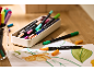 Bunte Dual-Tip-Marker und Zeichnungen auf einem Holztisch.