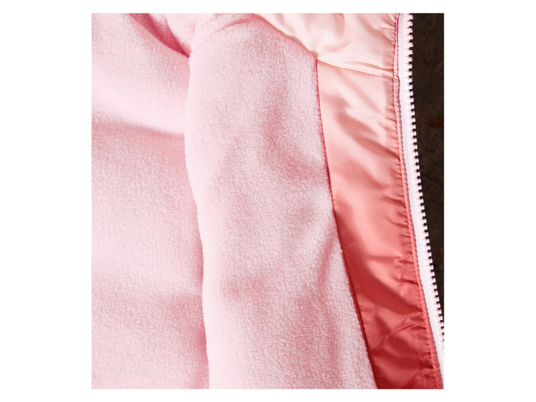 Detail einer rosa Fleecejacke mit weißem Reißverschluss.