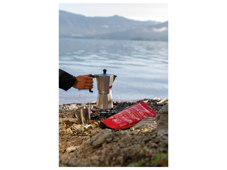 Eine Person brüht Kaffee mit einer Kanne und einem 'Somdecke' Anti-Fire & Anti-Smoke-Beutel.