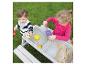 Zwei Kinder spielen mit einem Sand- und Wassertisch im Garten.