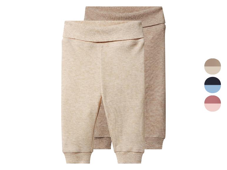 Zwei beige und hellbraune Babyhosen mit Bündchen und umklappbarem Bund.
