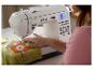 Weiße Nähmaschine mit Digitalanzeige, zum Nähen eines Musters auf einen Pullover.