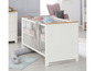 Ein weißes Babybett mit Holzdetails und einem grauen Plüschtier.