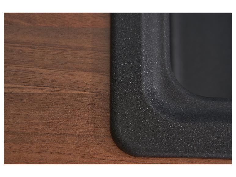 Nahaufnahme einer dunkelbraunen Holzoberfläche und einer schwarzen, texturierten Kante.