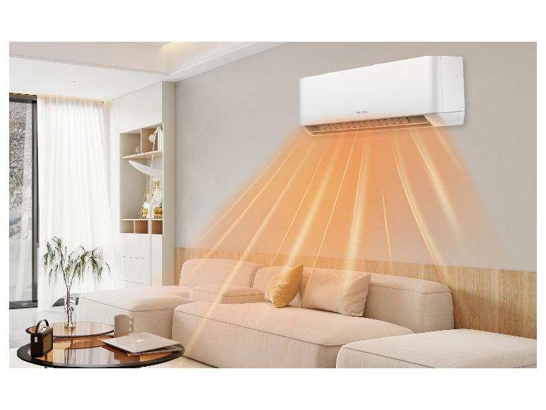 Weiße Klimaanlage heizt ein modernes Wohnzimmer mit beigem Sofa.