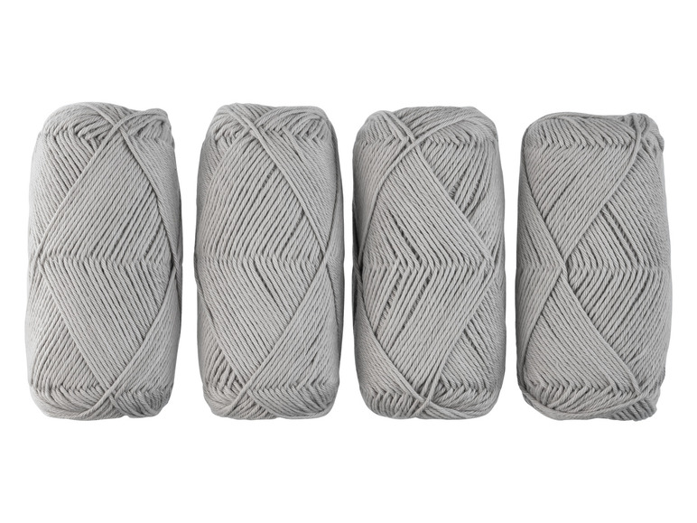 Vier Knäuel graues Garn zum Stricken oder Häkeln.