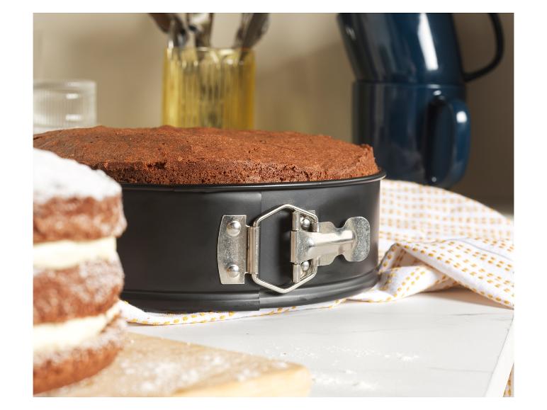 Ein gebackener Kuchen in einer Springform auf einer weißen Arbeitsfläche.