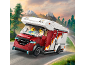 Spielzeug-Wohnmobil mit Figuren, fährt auf einer Bergstraße.
