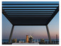 Ein gedeckter Tisch unter einer Metallpergola mit Blick aufs Meer
