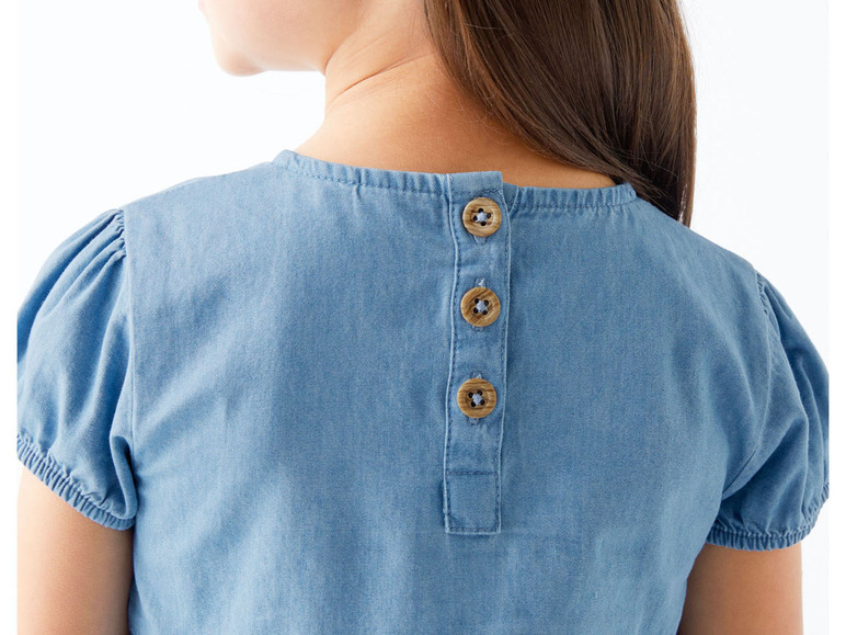 Ein blaues Jeanskleid mit Knöpfen auf dem Rücken.