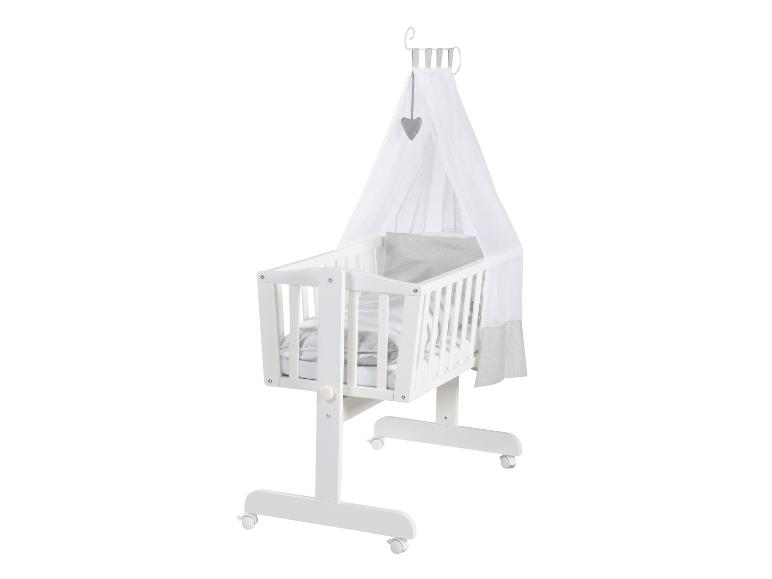 Weißes Babybett mit Himmel und grauer Bettwäsche