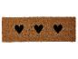 Braune Fußmatte mit drei schwarzen Herzen.