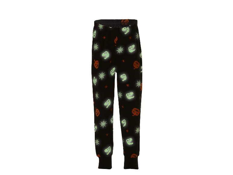 Schwarze Pyjamahose mit Halloween-Motiv: Kürbisse, Spinnennetze und Dinosaurierskelette.