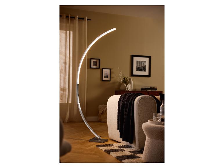 Moderne gebogene LED-Stehlampe beleuchtet ein gemütliches Wohnzimmer mit Sofa und Deko.