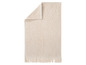 Beige Handtuch mit geometrischem Muster und Fransen.