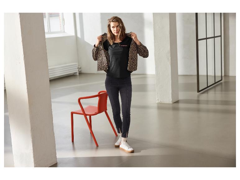Frau in dunkler ESMARA Jeggings, schwarzem T-Shirt und Leopardenjacke.