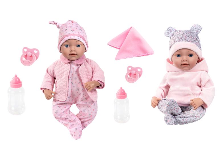 Zwei Babypuppen in rosa Kleidung mit Fläschchen und Schnullern.