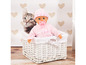 Eine Baby-Puppe mit Schnuller in einem weißen Korb mit einem Katzenkissen.