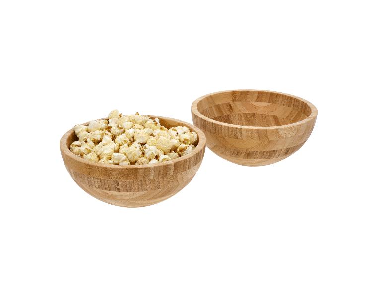 Zwei Holzschalen, eine gefüllt mit Popcorn, die andere leer.